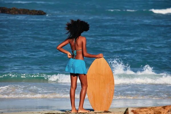 Plajda Sörf Tahtası Olan Kıvırcık Saçlı Genç Bir Kız Sporları — Stok fotoğraf