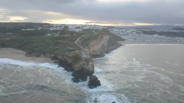 Un lugar emblemático en la costa atlántica, la Meca del surf de olas grandes. Vista del faro de Nazares en Zon North Canyon, lugar con las olas más grandes de Europa, Nazare, Portugal — Vídeos de Stock