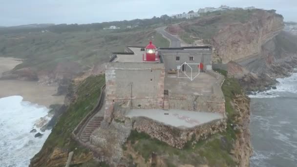 Een iconische plek aan de Atlantische kust, het Mekka van big-wave surfen. Uitzicht op de vuurtoren van Nazares in Zon North Canyon, plaats met de grootste golven van Europa, Nazare, Portugal — Stockvideo