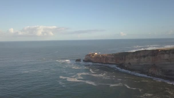 Een iconische plek aan de Atlantische kust, het Mekka van big-wave surfen. Uitzicht op de vuurtoren van Nazares in Zon North Canyon, plaats met de grootste golven van Europa, Nazare, Portugal — Stockvideo