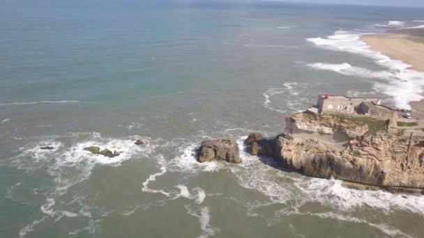 Kultowe miejsce na wybrzeżu Atlantyku, Mekka surfowania na dużej fali. Widok na latarnię morską Nazares w Zon Północny Kanion, miejsce z największymi falami w Europie, Nazar, Portugalia — Wideo stockowe