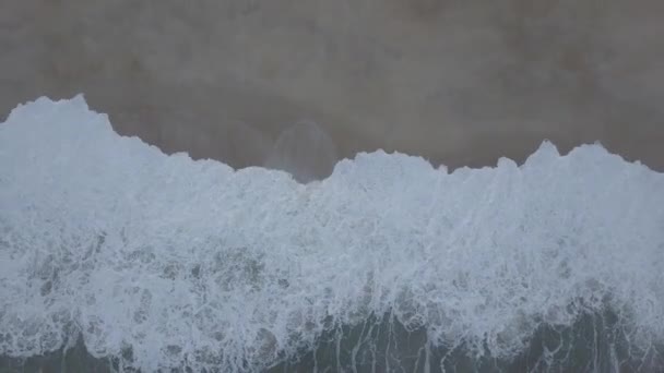 Survoler une plage de sable. Les vagues se brisent sur une plage de sable fin sur la côte atlantique, vue aérienne. Nazare, Portugal. vidéo brute — Video