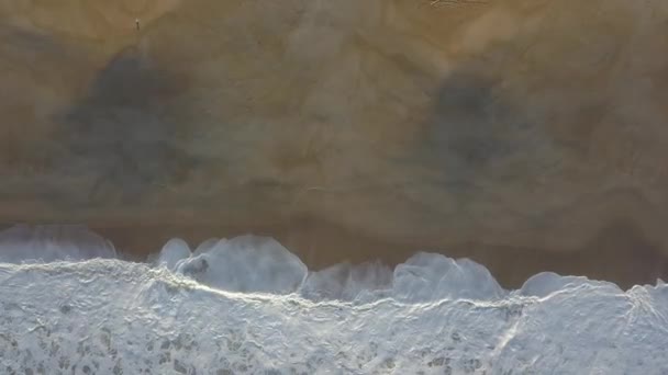 Летал над песчаным пляжем. Волны разбиваются на песчаном пляже на Атлантическом побережье, вид с воздуха. Назар, Португалия. сырое видео — стоковое видео