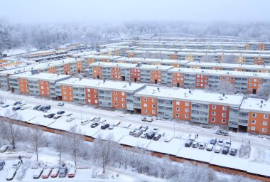 Kışın yağan kar sonrası 1960 'ların İsveç yerleşim bölgesi. Etrafı ormanlarla çevrili binalar. Renkli manzara, hava manzarası. Tby, Stockholm, İsveç