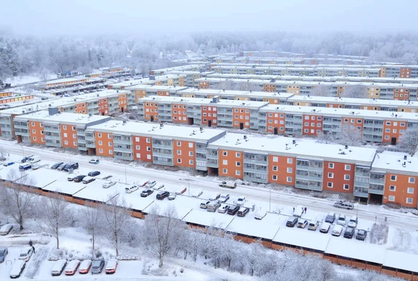 Kışın yağan kar sonrası 1960 'ların İsveç yerleşim bölgesi. Etrafı ormanlarla çevrili binalar. Renkli manzara, hava manzarası. Tby, Stockholm, İsveç