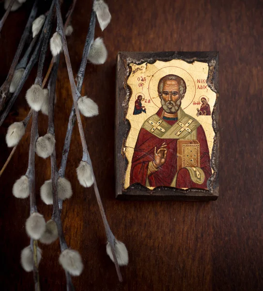 Moskova, Rissia - 20 Nisan 2020: Aziz Nicholas 'ın yaldızlı bir simgesi ve koyu ahşap arka planda söğüt dalları. Paskalya Bayramı, Palm Sunday. Ortodoks Hıristiyanlık, Hıristiyan sembolleri.