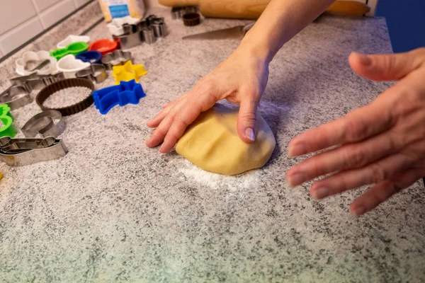 A child bakes cookies with mum or grandma, rolls out the dough and uses moulds to make the cookie cuttings in the Christmas time