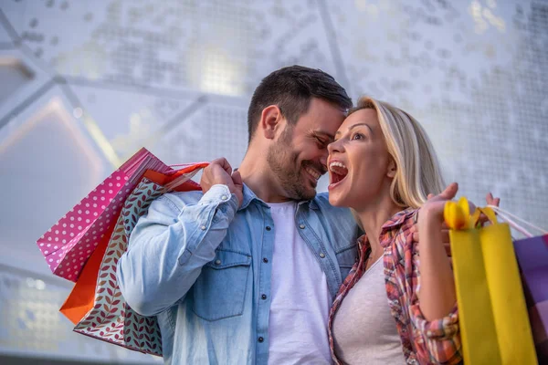 Birlikte alışveriş turunda gülümseyen mutlu çiftin portresi. İnsanlar, satış, eğlence ve tüketim konsepti..