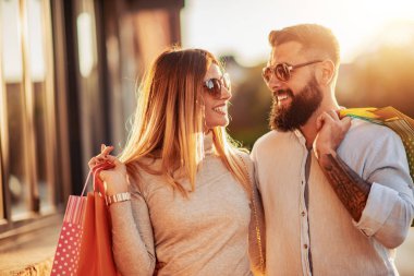 Alışveriş yaptıktan sonra alışveriş torbası taşıyan çift.