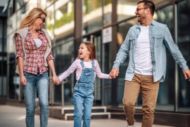 Mutlu gülümseyen bir aile ve açık havada bir kız.
