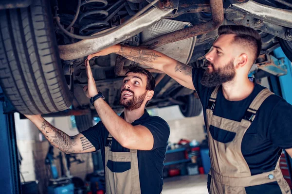 Due meccanici che riparano l'automobile nel centro di servizio — Foto Stock