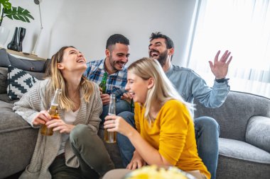 Bir grup arkadaş televizyonda futbolu seviyorlar.