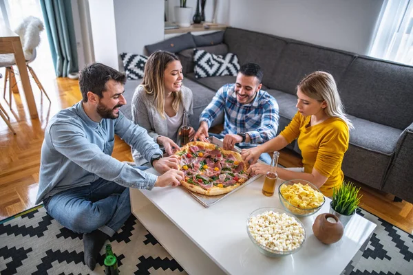 People having party at home and eating pizza