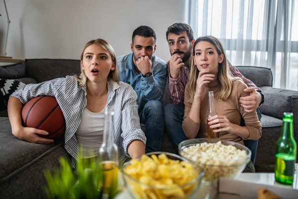 Groep vrienden kijken basketbal op tv — Stockfoto