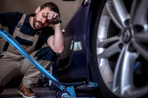 Mecânico trabalhando em pneus de carro em sua loja — Fotografia de Stock