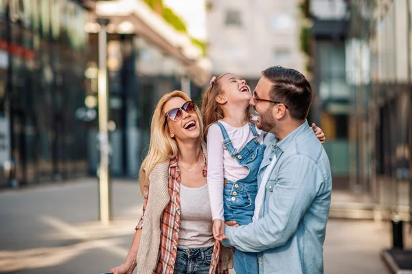 Jovem família feliz de três sorrindo enquanto passam o tempo juntos — Fotografia de Stock