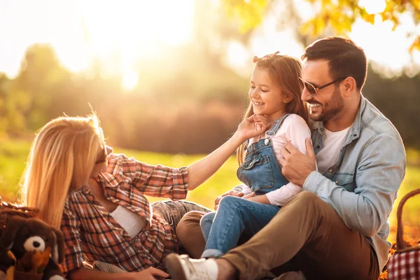 Aile güneşli bir günde piknikte.