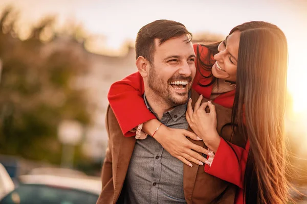 Feliz joven hombre piggybacking su novia — Foto de Stock