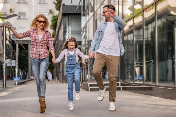 Jovem família feliz de três sorrindo enquanto passam o tempo juntos — Fotografia de Stock