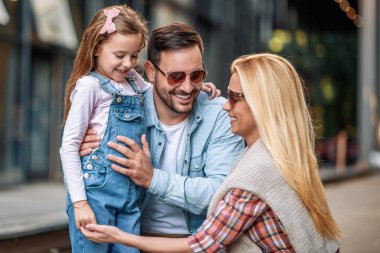 Neşeli genç aile dışarıda birlikte vakit geçiriyor. Mutlu aile dışarıda. Aşk ve mutluluk kavramı..