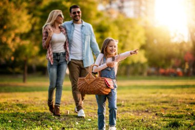 Mutlu aile yaz parkında dinleniyor. Neşeli aile parkta piknik yapıyor. Yaz zamanı ve tatil konsepti..