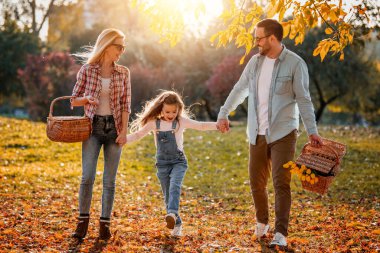Mutlu aile yaz parkında dinleniyor. Neşeli aile parkta piknik yapıyor. Yaz zamanı ve tatil konsepti..