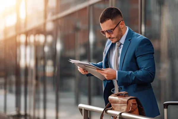 Uluslararası havaalanındaki genç işadamları uçak seyahati için terminal kapısına gidiyorlar. İş ve seyahat kavramı. İş gezisi..