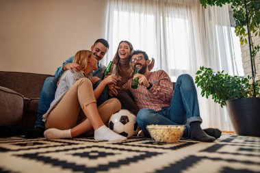 Bir grup arkadaş birlikte maç izliyor. Çok heyecanlı arkadaşlar evde eğleniyor, futbol maçı izliyorlar. Arkadaşlık, kiralama, insanlar ve ev partisi konsepti..