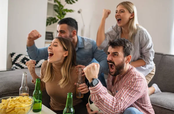 Group of friends watching sport together.Very excited friends having fun at home, watching football match.Friendship,leasure,people and home party concept.