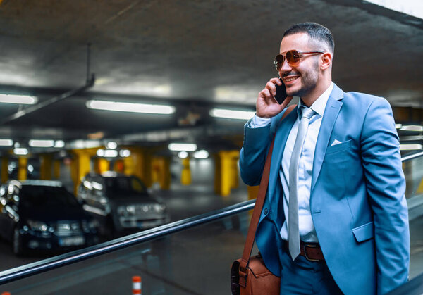 Attractive young businessman using smart phone.Portrait of handsome businessman outdoor in the city.