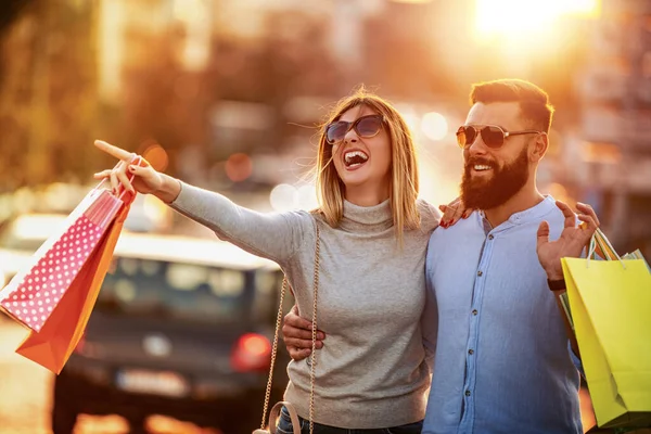 Its time for shopping.Happy couple carrying shopping bags and enjoying together on summer day.