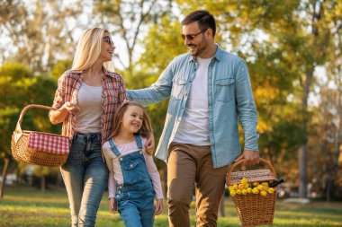 Mutlu aile doğada piknik yapıyor. Gülümseyen aile parkta piknik yapıyor..