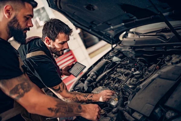 Two Young Car Mechanics Checking Engine Oil Level — Stock Photo, Image