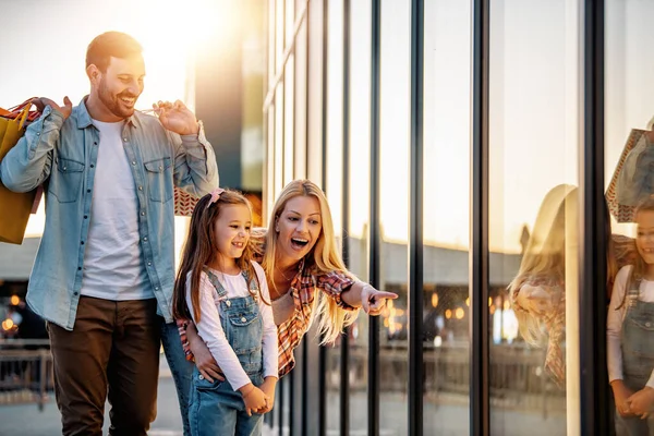 Güzel ebeveynler ve alışveriş çantalı kızları. Bir sürü alışveriş çantalı mutlu aile..