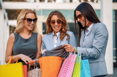 Alışveriş çantasıyla gülümseyen iş kadınlarının portresi. İnsanlar, moda ve alışveriş konsepti..
