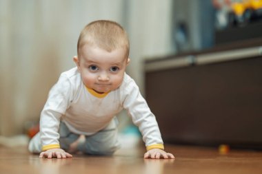 Yerde sürünen gülümseyen bebek. Sevimli bebeğin parlak portresi..