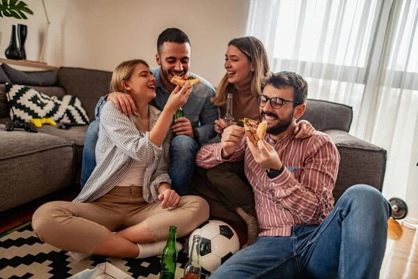 Group of cheerful friends eating delicious pizza.Happy friends having party at home.People,happiness and fun concept.