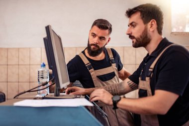 İki modern tamirci tamirde çalışıyor. Takım çalışması konsepti..