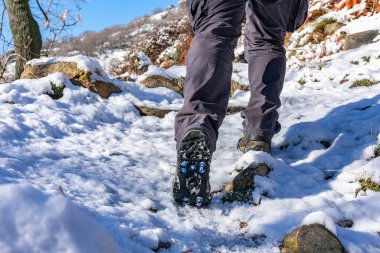 Karda yürüyen botları ve şişleri olan adamın bacakları.