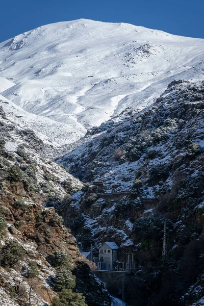 Hydroelectric power station in a snow-covered ravine.