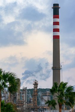 Rafineri manzarası, rafine kuleleri ve tüten bacaları var.
