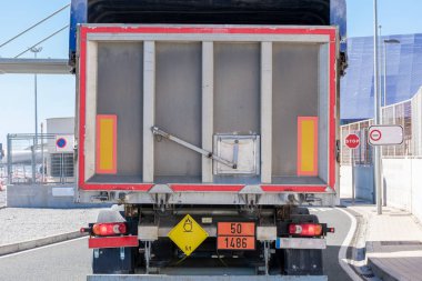 Tehlikeli ürün plakalı bir kamyonun arka görüntüsü. Kimlik numaraları, oksitlenen katı maddeler, gübreler..