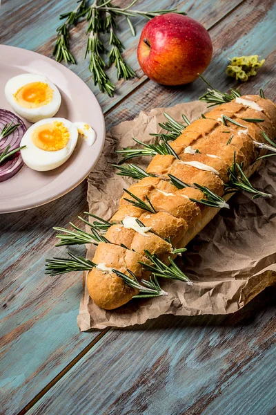 Mutfak masasında yumurtalı ve otlu baget.
