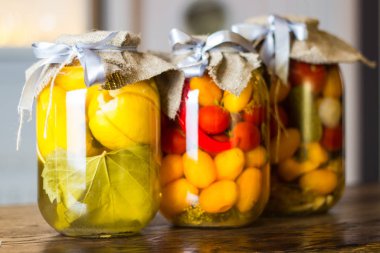 ahşap masa üzerinde sebze konserveler