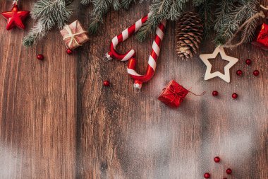 Kahverengi ahşap arka plan görünümlü Noel süslemeleri ve köknar dalları