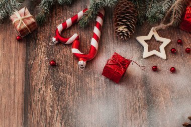 Kahverengi ahşap arka plan görünümlü Noel süslemeleri ve köknar dalları