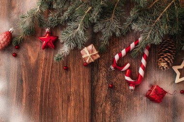 Kahverengi ahşap arka plan görünümlü Noel süslemeleri ve köknar dalları