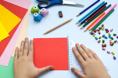 Kırmızı kağıttan origami kuş çocuk ellerin yaptığını.