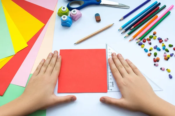 Kırmızı kağıttan origami kuş çocuk ellerin yaptığını.