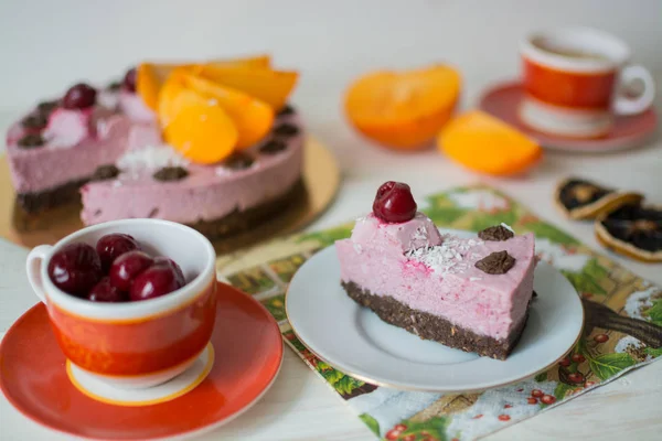 Ham pasta, kırmızı bardak papatya çayı, kiraz bir fincan, ahşap arka plan üzerinde bir Trabzon hurması